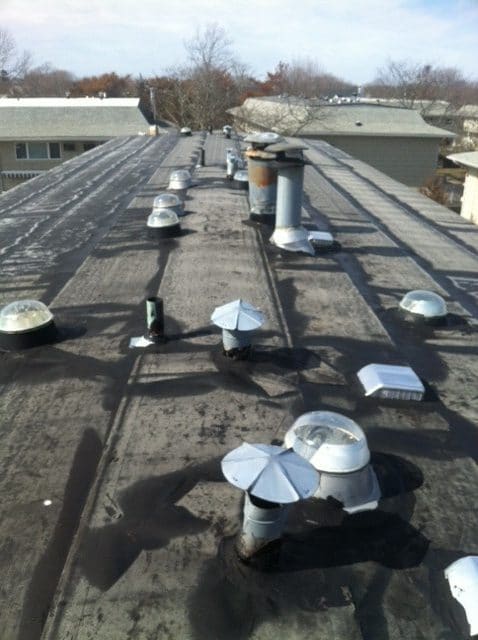 dark flat roof building with chimney vents